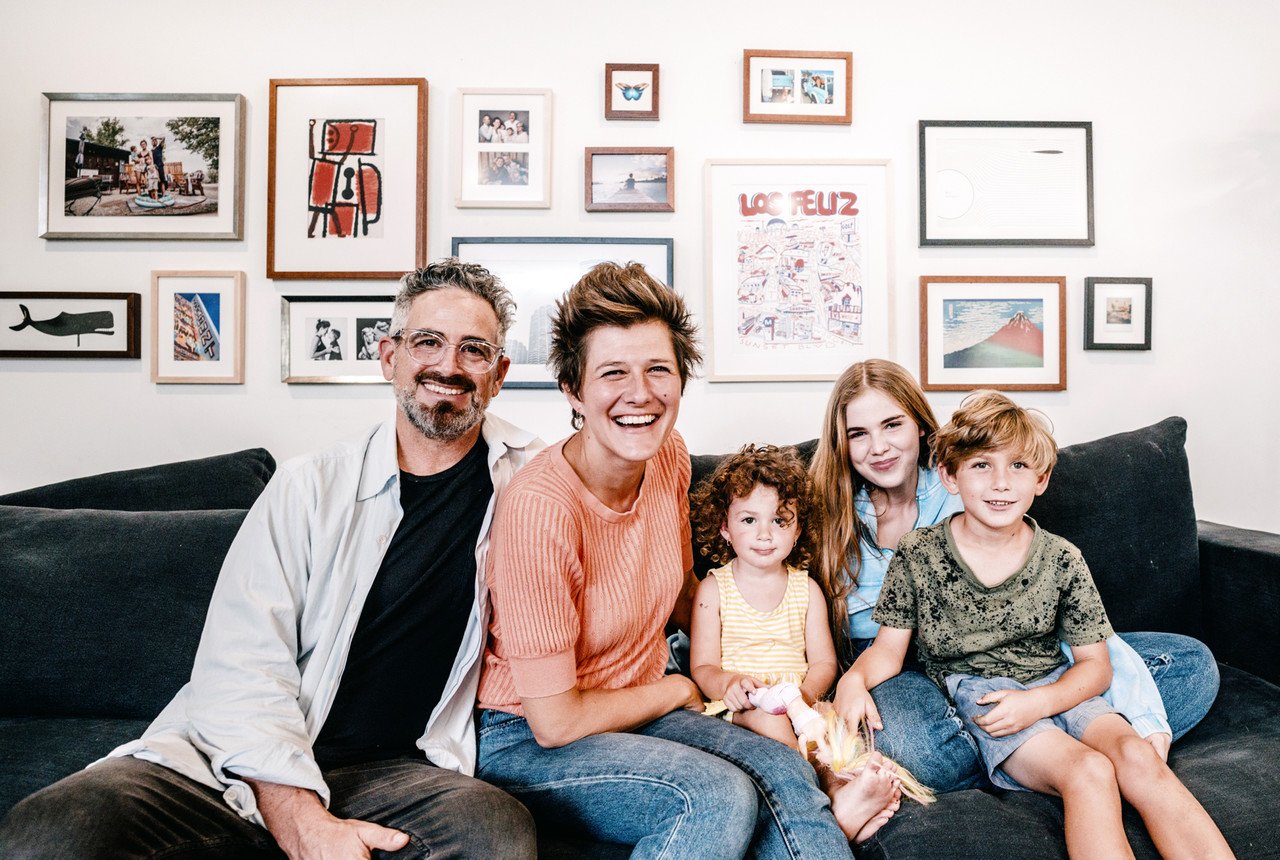 Happy family with their gallery wall of framed photos and art